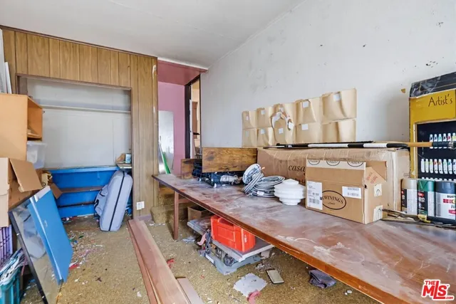 a view of a patio with table and chairs potted plants and floor to ceiling window
