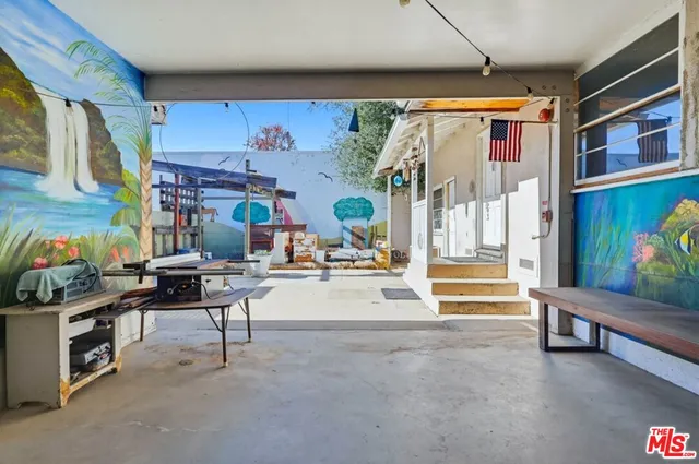 a view of a patio with table and chairs under an umbrella