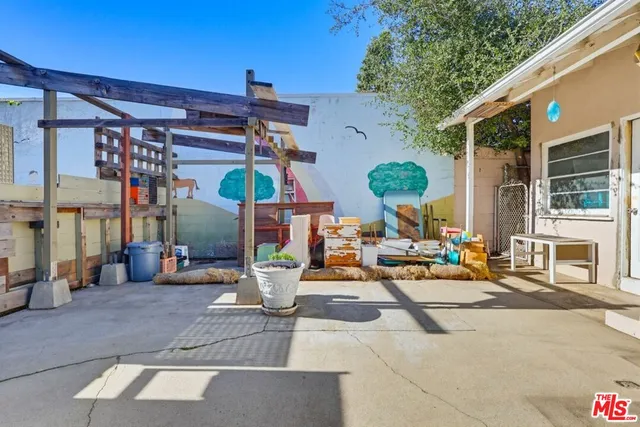 a living room with furniture a flat screen tv and a refrigerator
