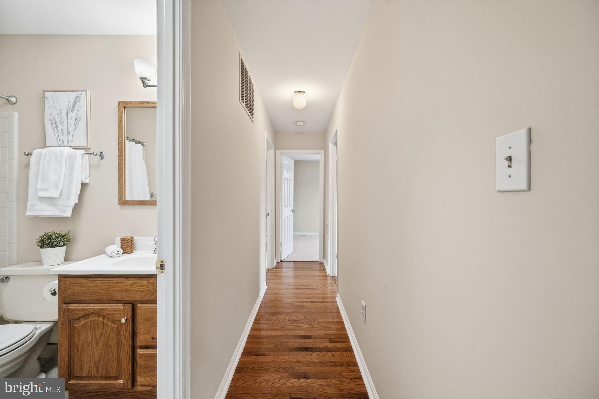 9322 Elk Drive Springfield, VA 22153 - Photo 19 of 43 a view of a hallway with wooden floor and a bathroom