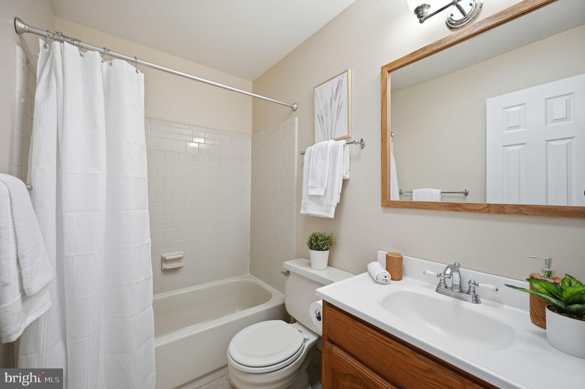 9322 Elk Drive Springfield, VA 22153 - Photo 24 of 43 a bathroom with a sink a toilet a mirror a shower and bathtub