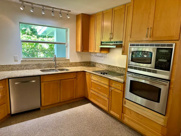 a kitchen with granite countertop a sink and cabinets