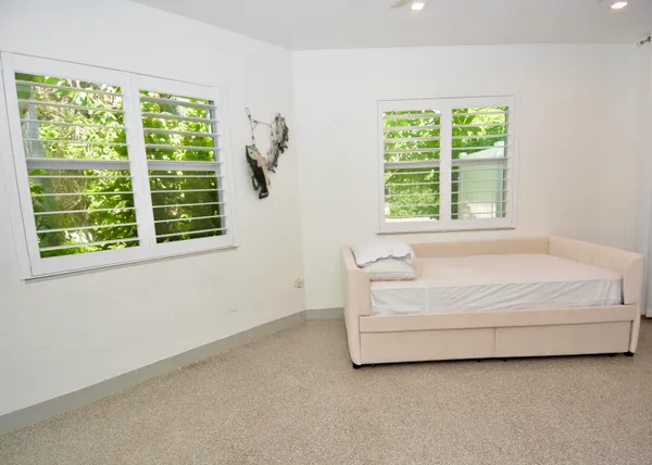 a spacious bedroom with a bed and a dresser