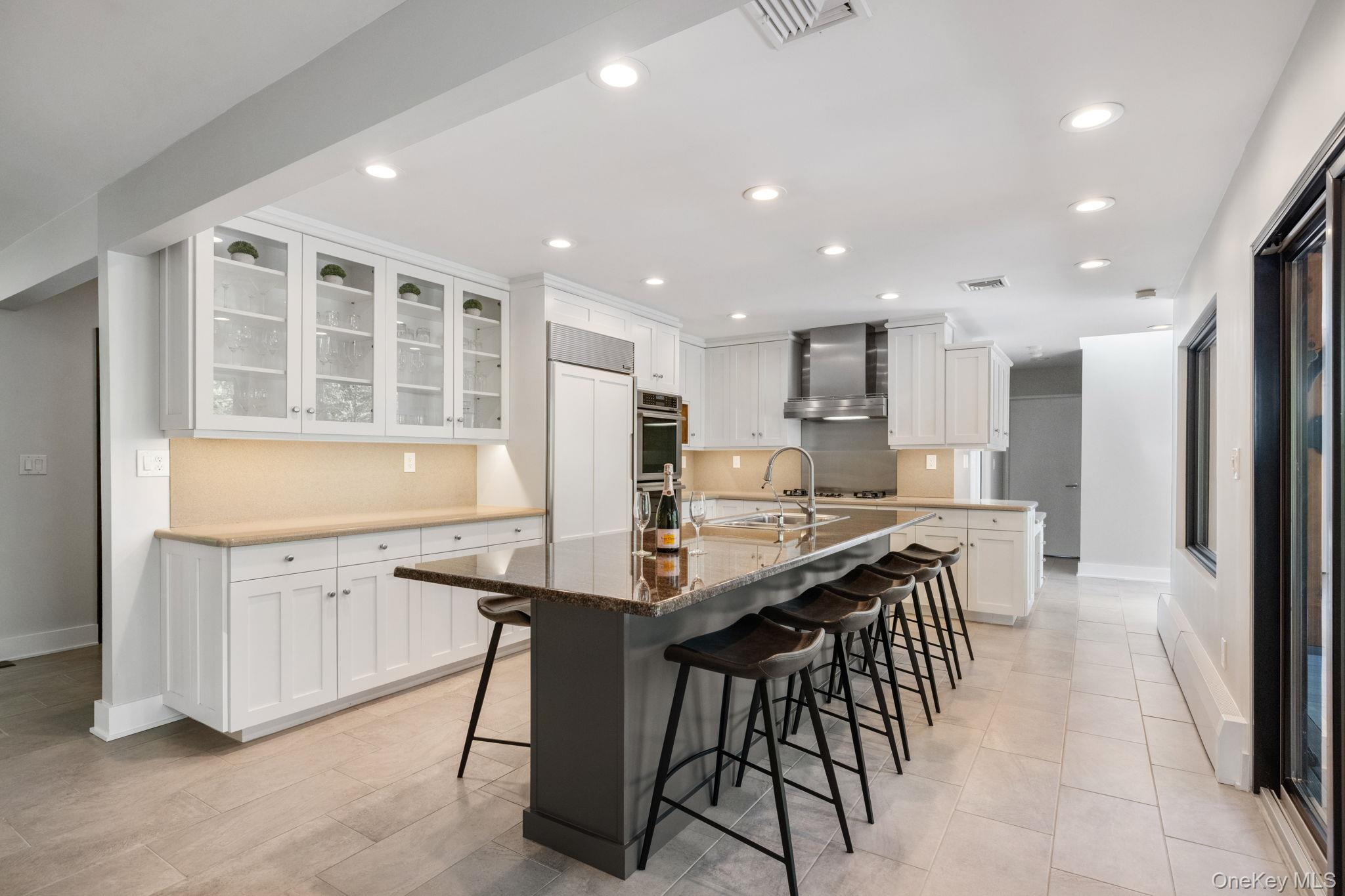 2 Logging Road Waccabuc, NY 10597 - Photo 5 of 46 a kitchen with stainless steel appliances kitchen island granite countertop a table chairs sink and cabinets