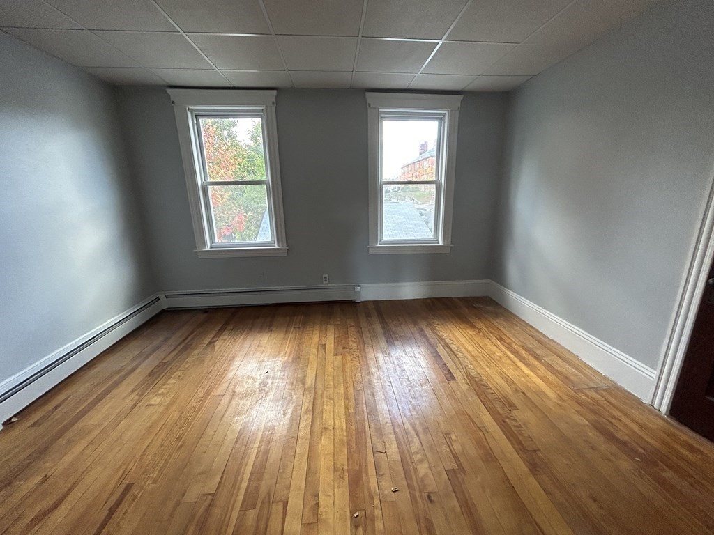 23 Greendale Avenue Worcester, MA 01606 - Photo 19 of 30 an empty room with wooden floor and windows