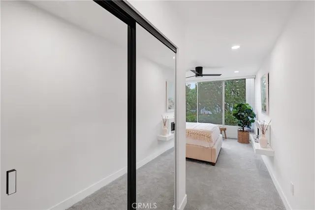 a bedroom with a large bed and a potted plant
