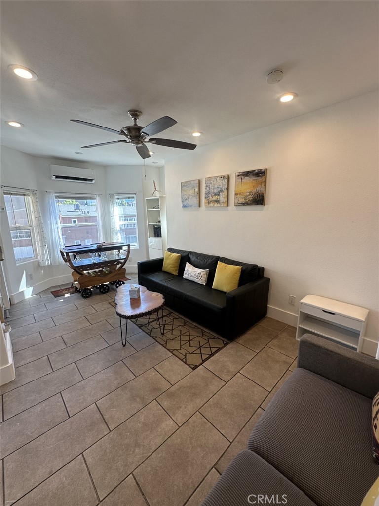 a living room with furniture and a ceiling fan