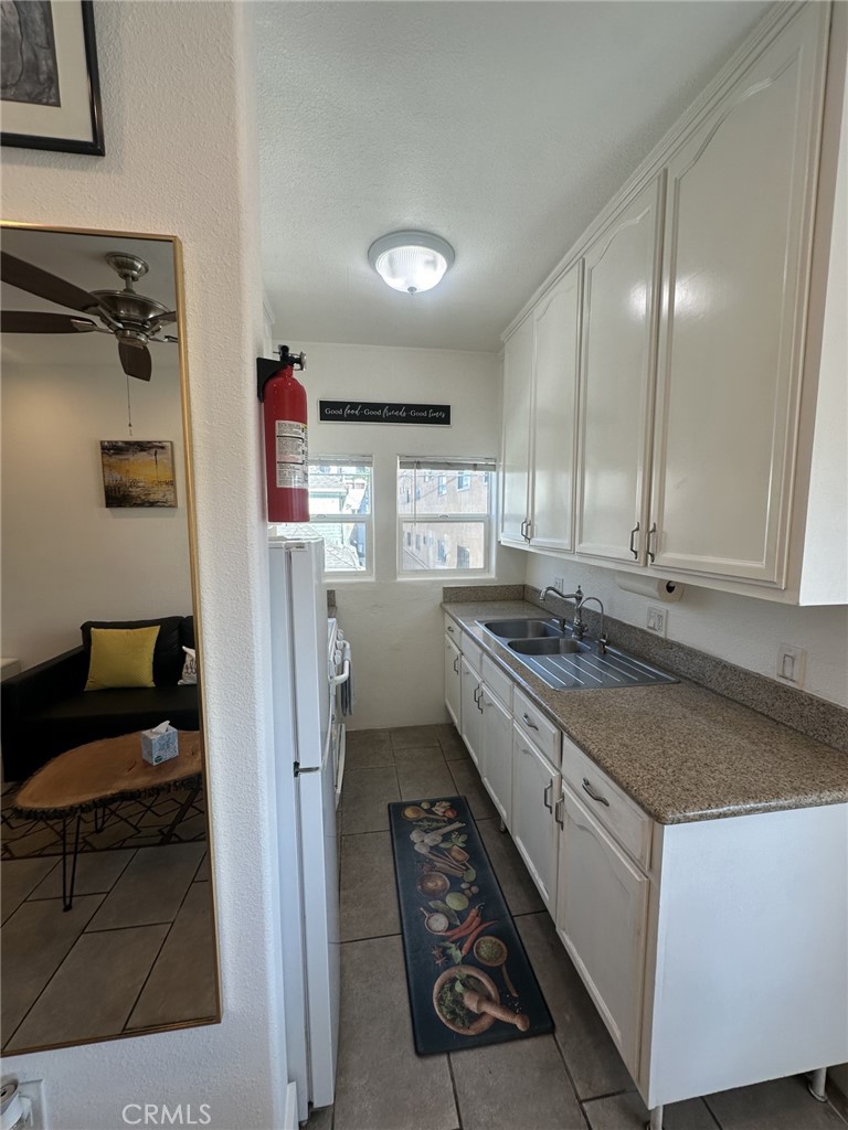 354 Chestnut Avenue, Unit 33 Long Beach, CA 90802 - Photo 12 of 18 a kitchen with granite countertop a sink stove and cabinets
