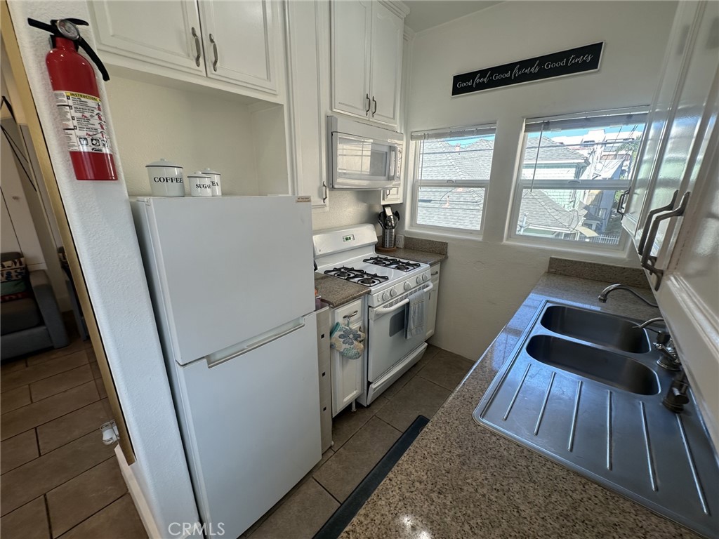 354 Chestnut Avenue, Unit 33 Long Beach, CA 90802 - Photo 15 of 18 a kitchen with a white stove top oven and sink