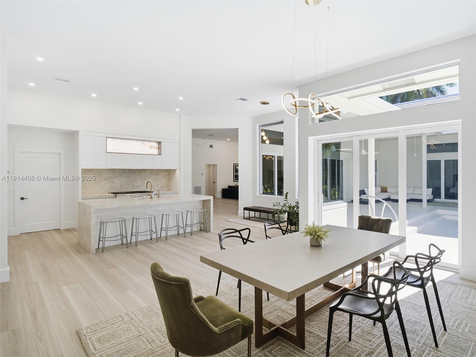 7675 Steeplechase Drive Palm Beach Gardens, FL 33418 - Photo 12 of 36 a kitchen with a dining table chairs and white cabinets