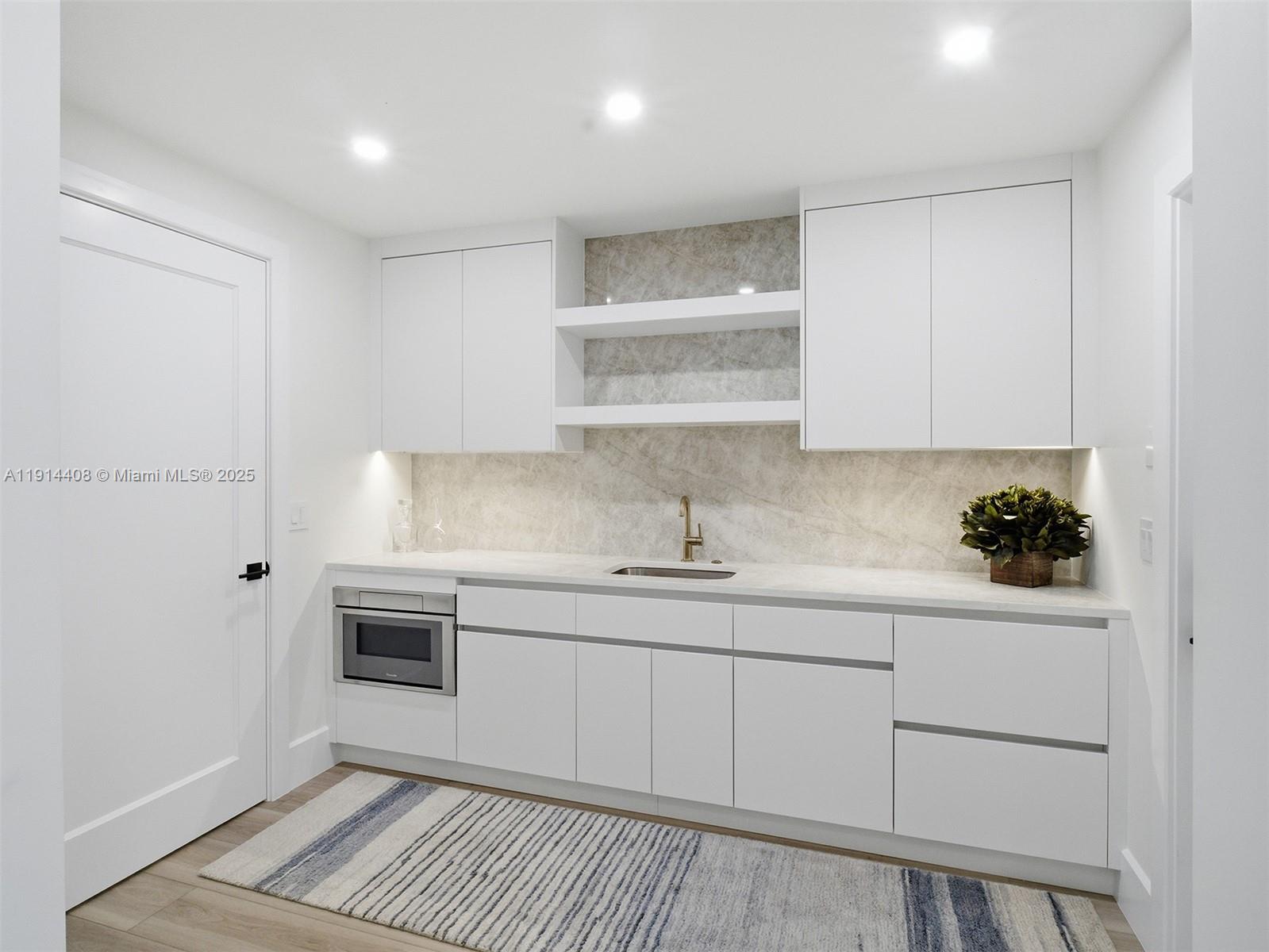 7675 Steeplechase Drive Palm Beach Gardens, FL 33418 - Photo 17 of 36 a kitchen with stainless steel appliances granite countertop a sink and cabinets