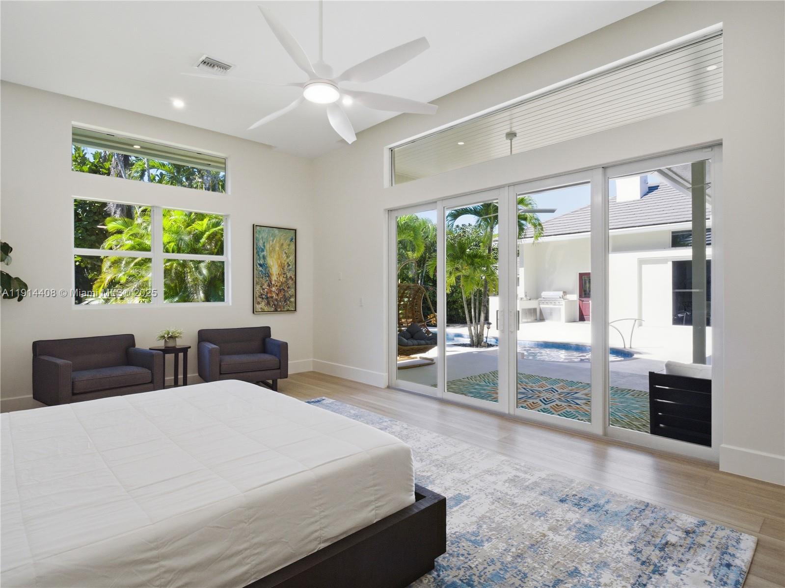 7675 Steeplechase Drive Palm Beach Gardens, FL 33418 - Photo 20 of 36 a bedroom with a large bed and a large window