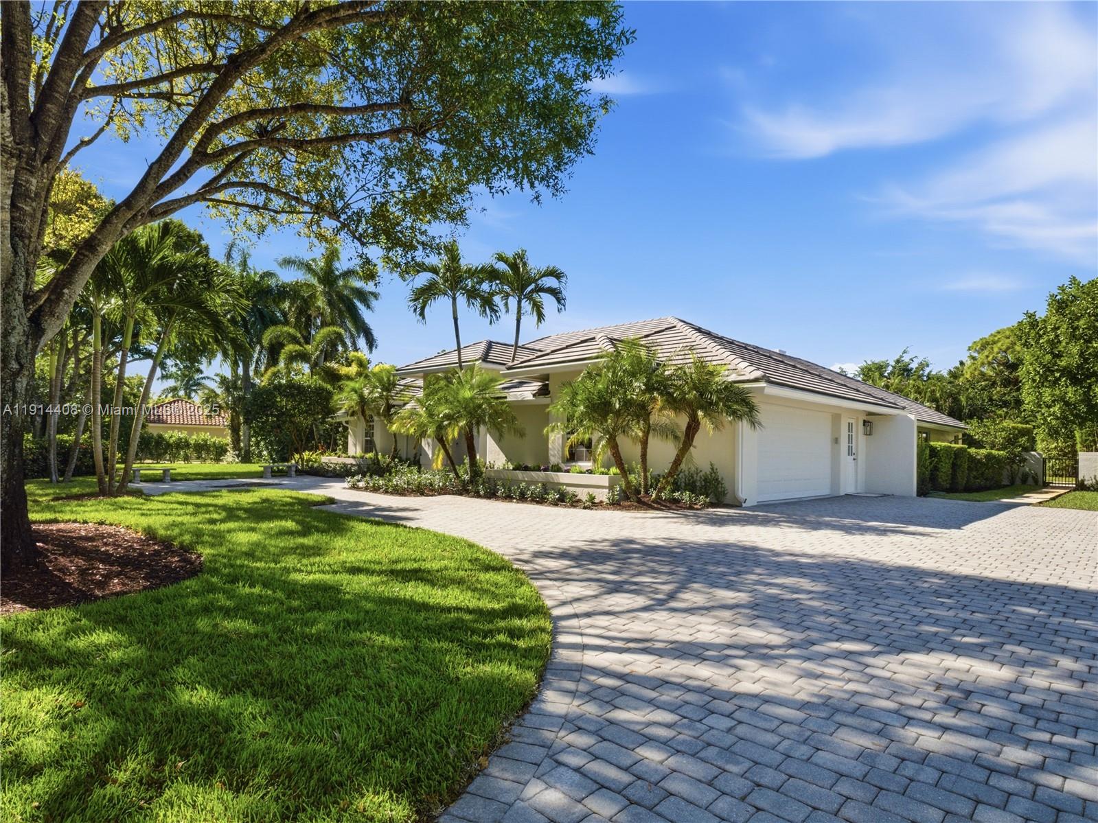 7675 Steeplechase Drive Palm Beach Gardens, FL 33418 - Photo 4 of 36 a front view of a house with a yard and garage
