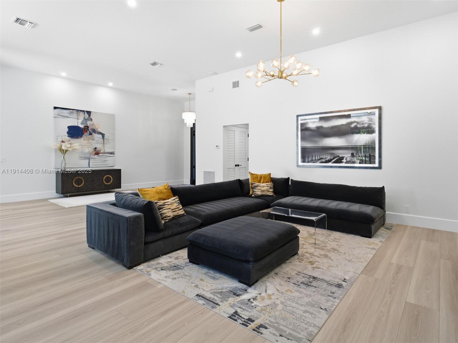 7675 Steeplechase Drive Palm Beach Gardens, FL 33418 - Photo 7 of 36 a living room with furniture and a chandelier