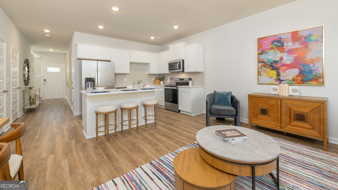 2080 Moss Hill Road Stone Mountain, GA 30088 - Photo 16 of 39 a living room with stainless steel appliances furniture a rug and a kitchen view