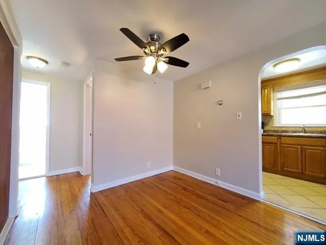 a view of a room with wooden floor and a ceiling fan