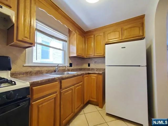 a kitchen with a refrigerator sink stove and cabinets