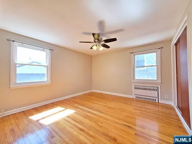 a view of a room with wooden floor and a ceiling fan
