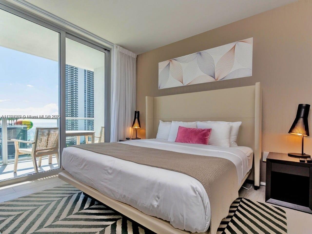 4010 South Ocean Drive, Unit R1005 Hollywood, FL 33019 - Photo 12 of 14 a bedroom with a bed and wooden floor