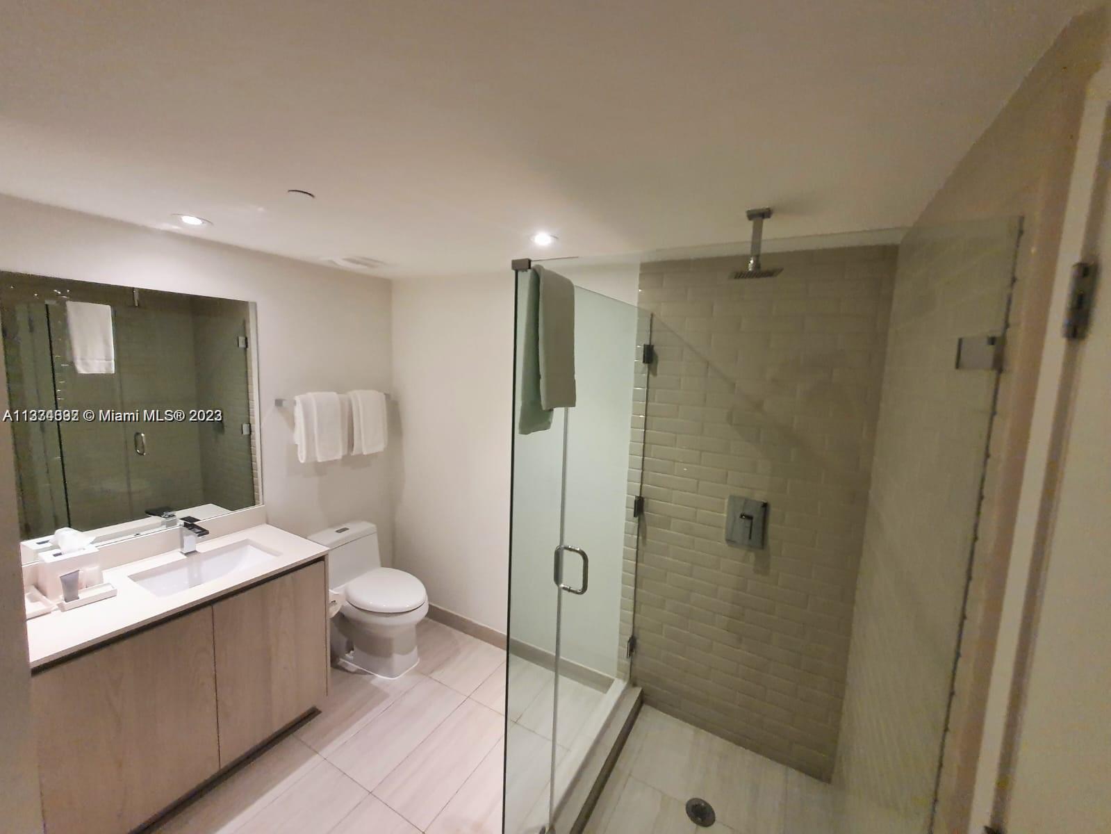 4010 South Ocean Drive, Unit R1005 Hollywood, FL 33019 - Photo 13 of 14 a bathroom with a shower sink mirror and toilet