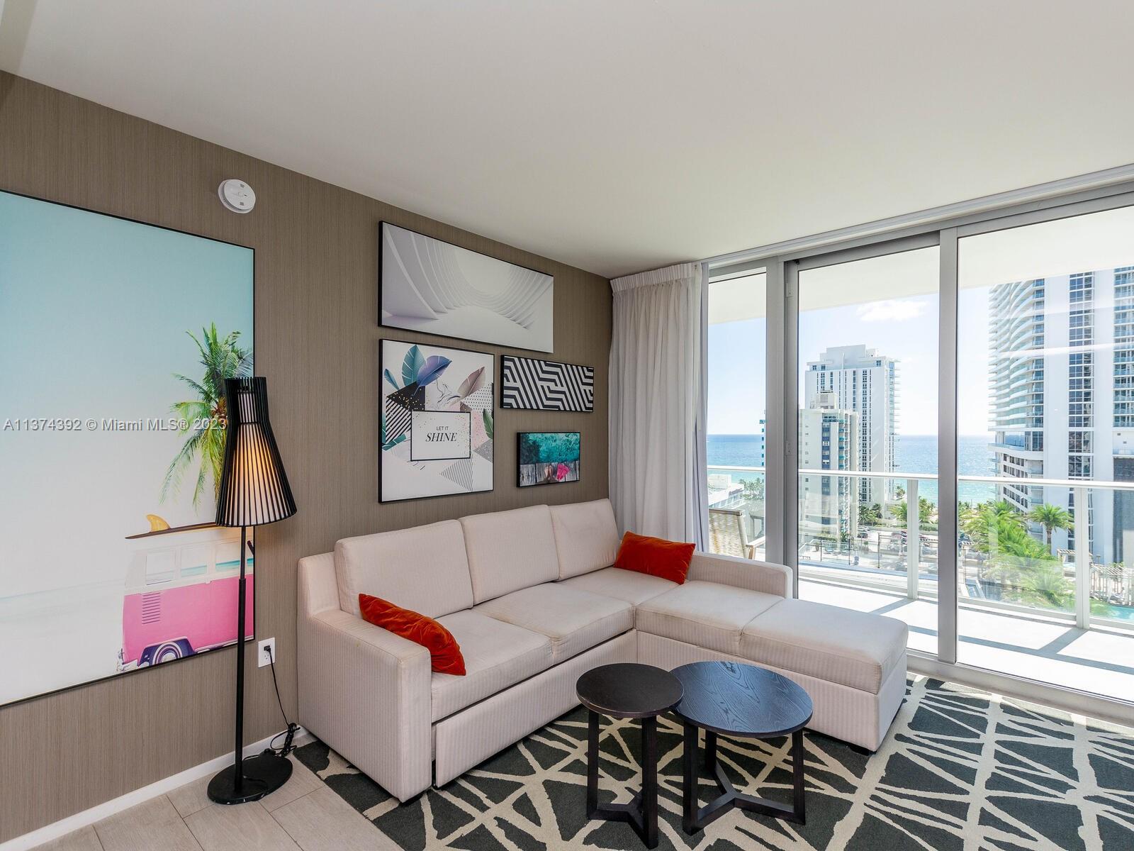 4010 South Ocean Drive, Unit R1005 Hollywood, FL 33019 - Photo 6 of 14 a living room with furniture and a floor to ceiling window