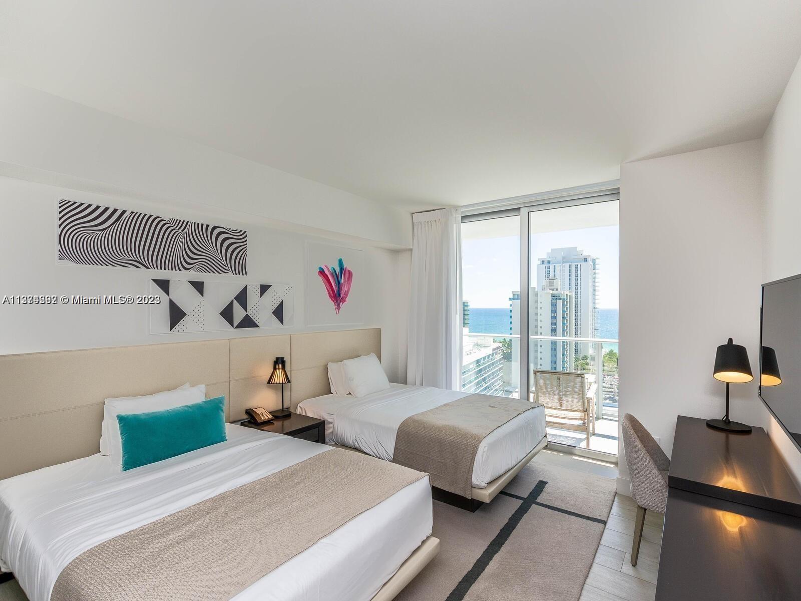 4010 South Ocean Drive, Unit R1005 Hollywood, FL 33019 - Photo 8 of 14 a bedroom with two beds and a large window with outer view