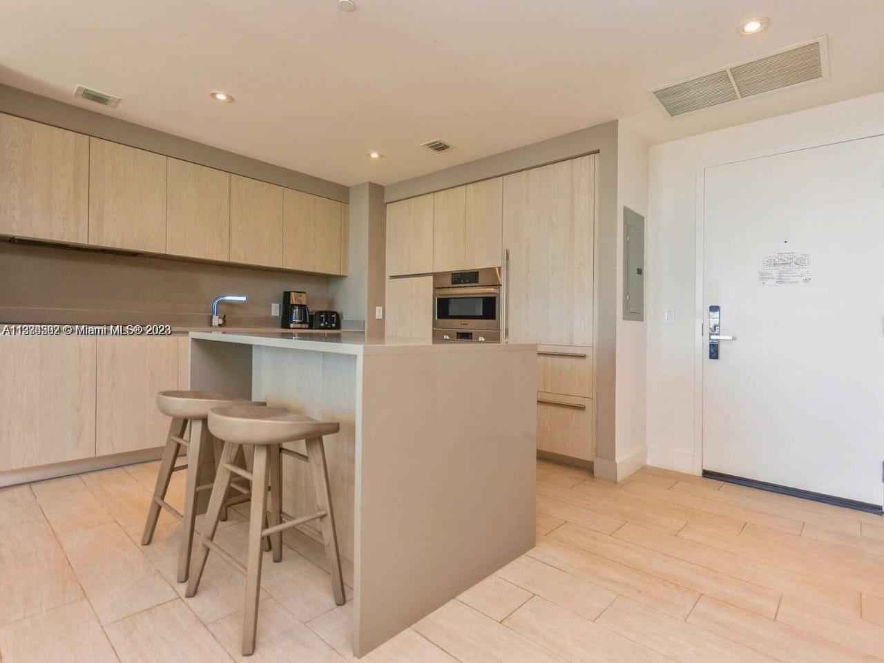 4010 South Ocean Drive, Unit R1005 Hollywood, FL 33019 - Photo 10 of 14 a kitchen with stainless steel appliances a refrigerator and a stove top oven