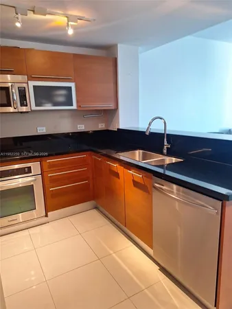 a kitchen with granite countertop a sink and a stove top oven