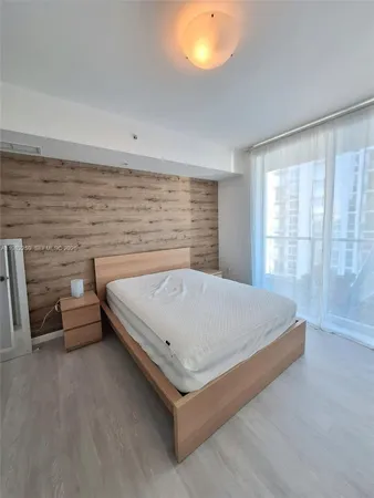 a bed sitting in a room next to a lamp