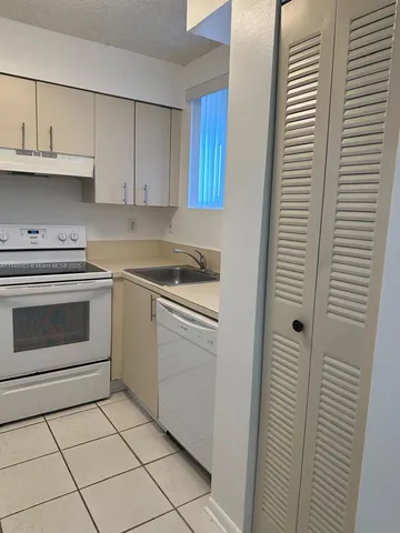 a kitchen with cabinets and white appliances