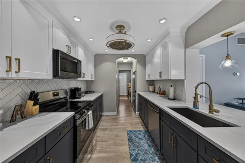a kitchen with stainless steel appliances a sink stove and cabinets