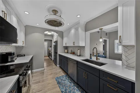 a kitchen with stainless steel appliances granite countertop a sink a stove and a microwave