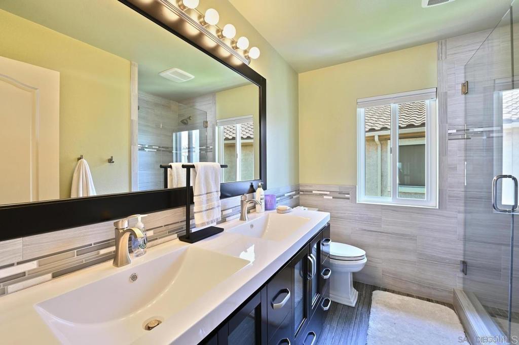 1035 Park Meadows Road Chula Vista, CA 91915 - Photo 23 of 35 a bathroom with a double vanity sink a mirror and a bathtub