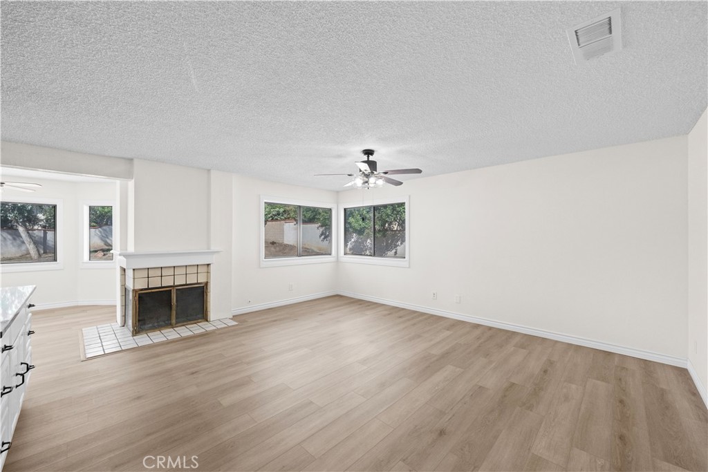 5498 Shadow Lane Rancho Cucamonga, CA 91737 - Photo 34 of 51 an empty room with fireplace wooden floor and windows