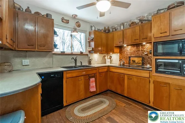 a kitchen with stainless steel appliances granite countertop a sink dishwasher stove and refrigerator with wooden floor