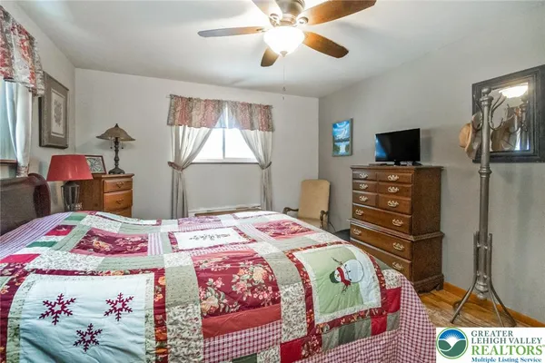 a bedroom with a bed a dresser and flat screen tv