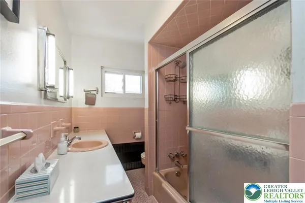 a bathroom with a sink a toilet a shower and a mirror