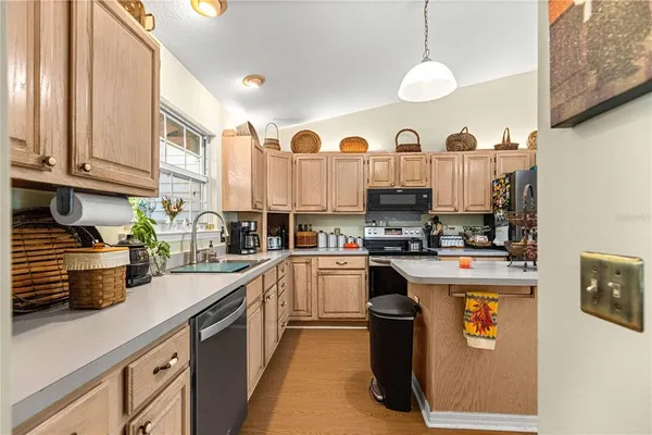a kitchen that has a lot of cabinets in it and wooden floors