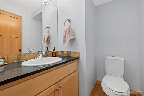 a bathroom with a granite countertop toilet sink and mirror