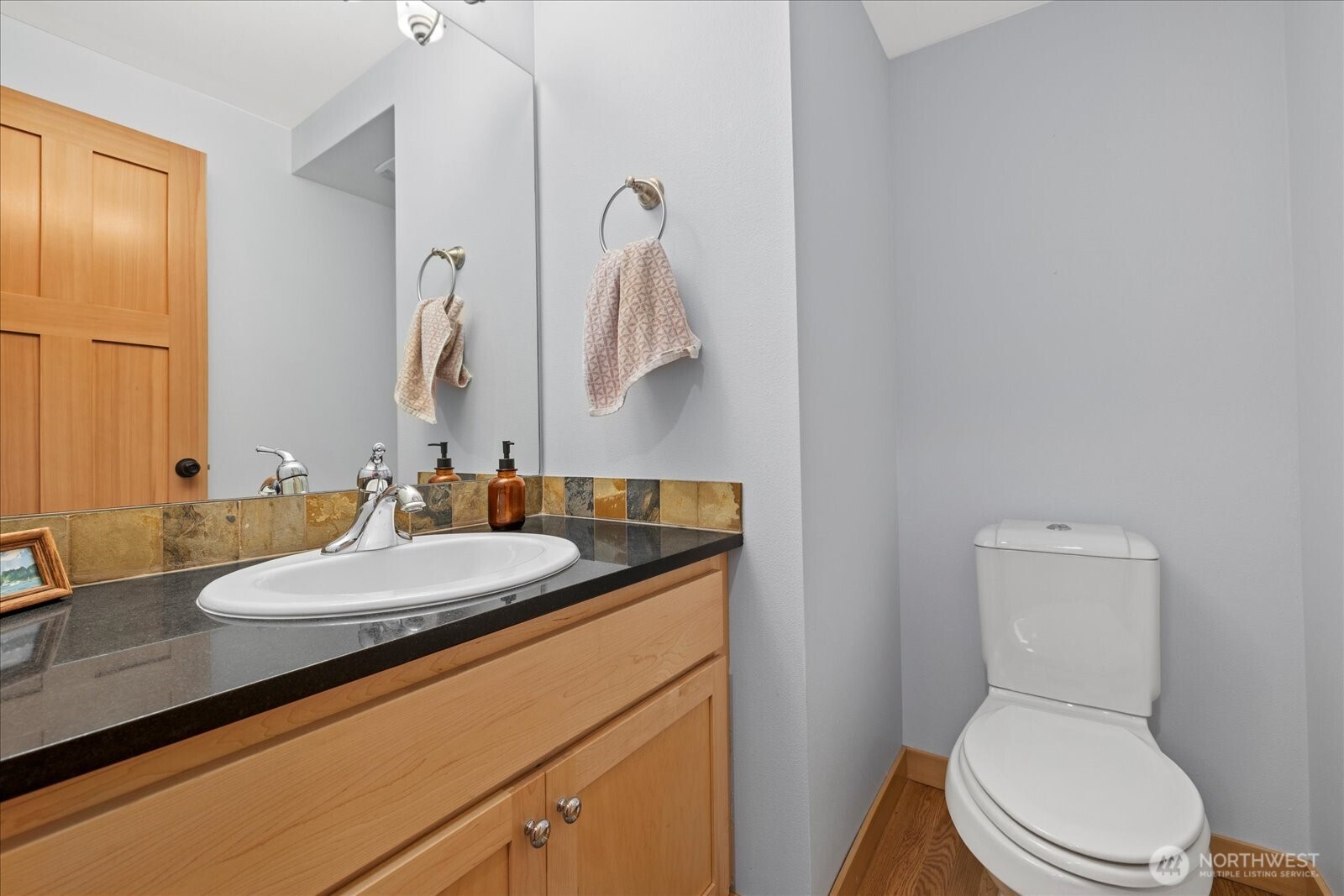9748 4th Avenue Northwest, Unit B Seattle, WA 98117 - Photo 13 of 24 a bathroom with a granite countertop toilet sink and mirror