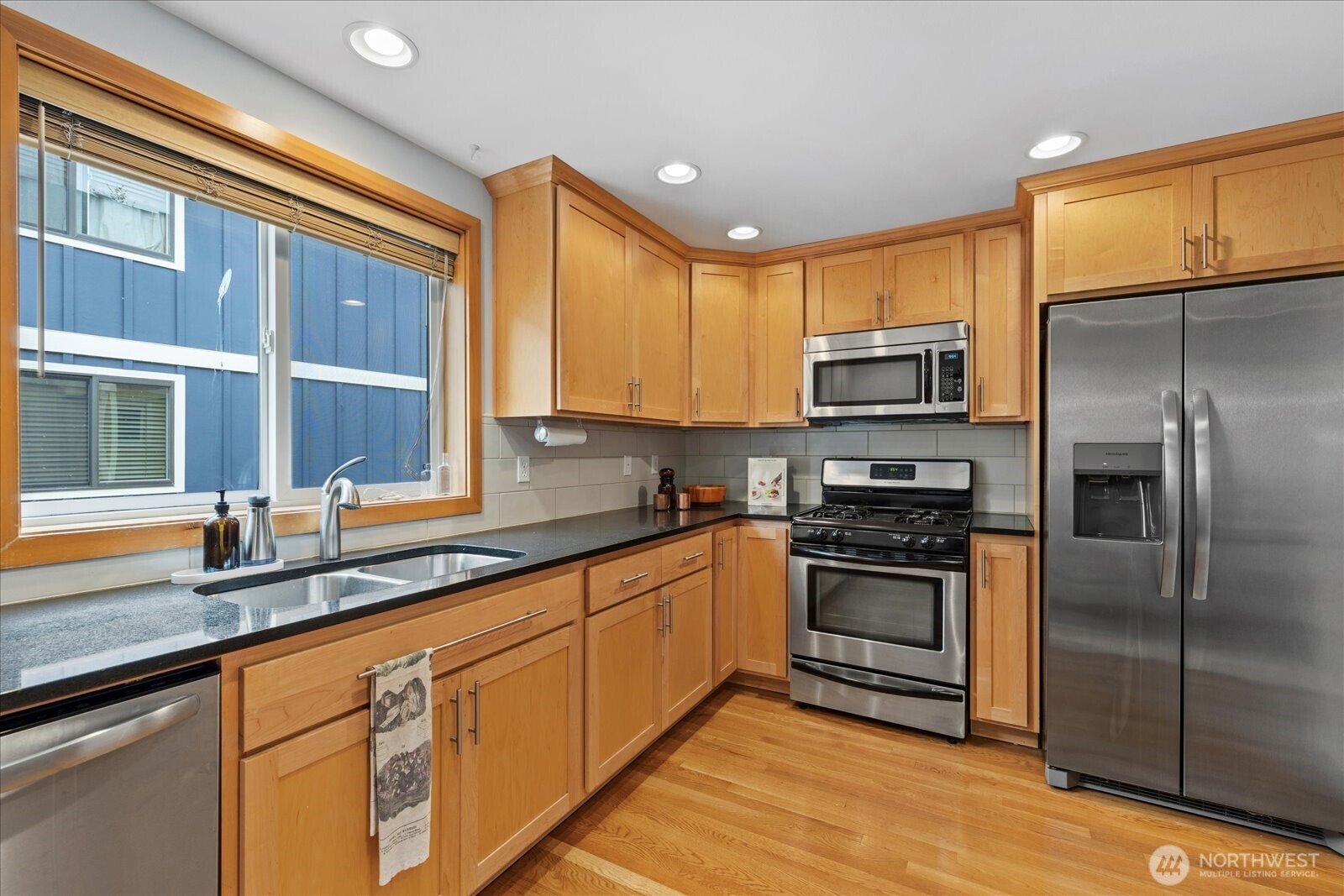 9748 4th Avenue Northwest, Unit B Seattle, WA 98117 - Photo 8 of 24 a kitchen with stainless steel appliances granite countertop a stove a sink and a refrigerator