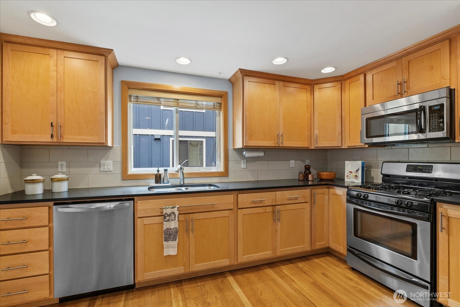9748 4th Avenue Northwest, Unit B Seattle, WA 98117 - Photo 9 of 24 a kitchen with stainless steel appliances granite countertop wooden cabinets and a stove top oven