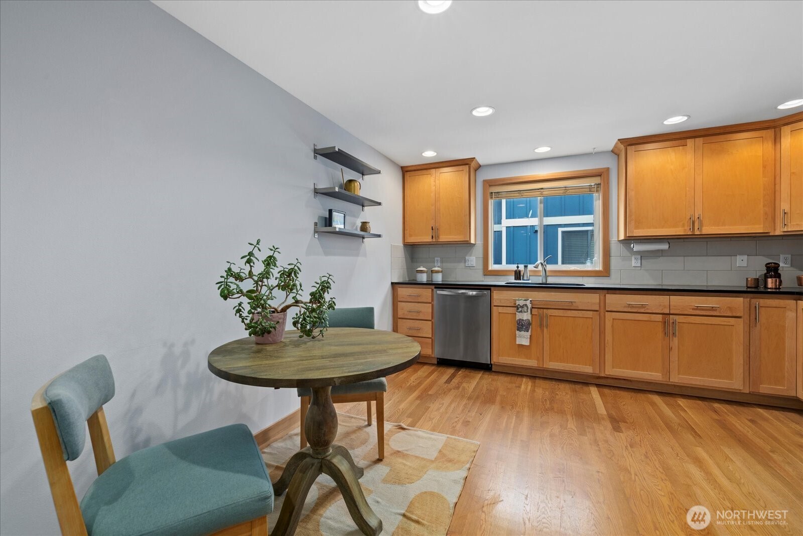 9748 4th Avenue Northwest, Unit B Seattle, WA 98117 - Photo 10 of 24 a kitchen with stainless steel appliances kitchen island a table and chair in it