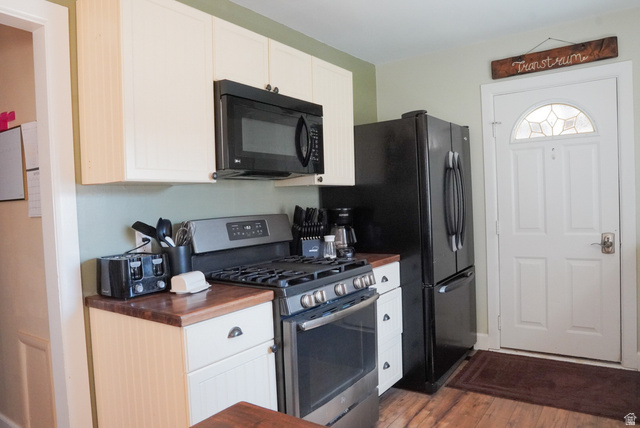 324 Stringtown Road Georgetown, ID 83239 - Photo 11 of 49 Kitchen featuring gas stove, black microwave, white cabinets, dark wood-style flooring, and wooden counters