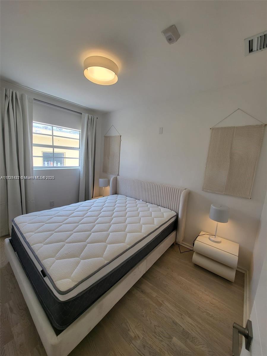 810 7th Street, Unit 206 Miami Beach, FL 33139 - Photo 5 of 7 a bed sitting in a bedroom next to a window