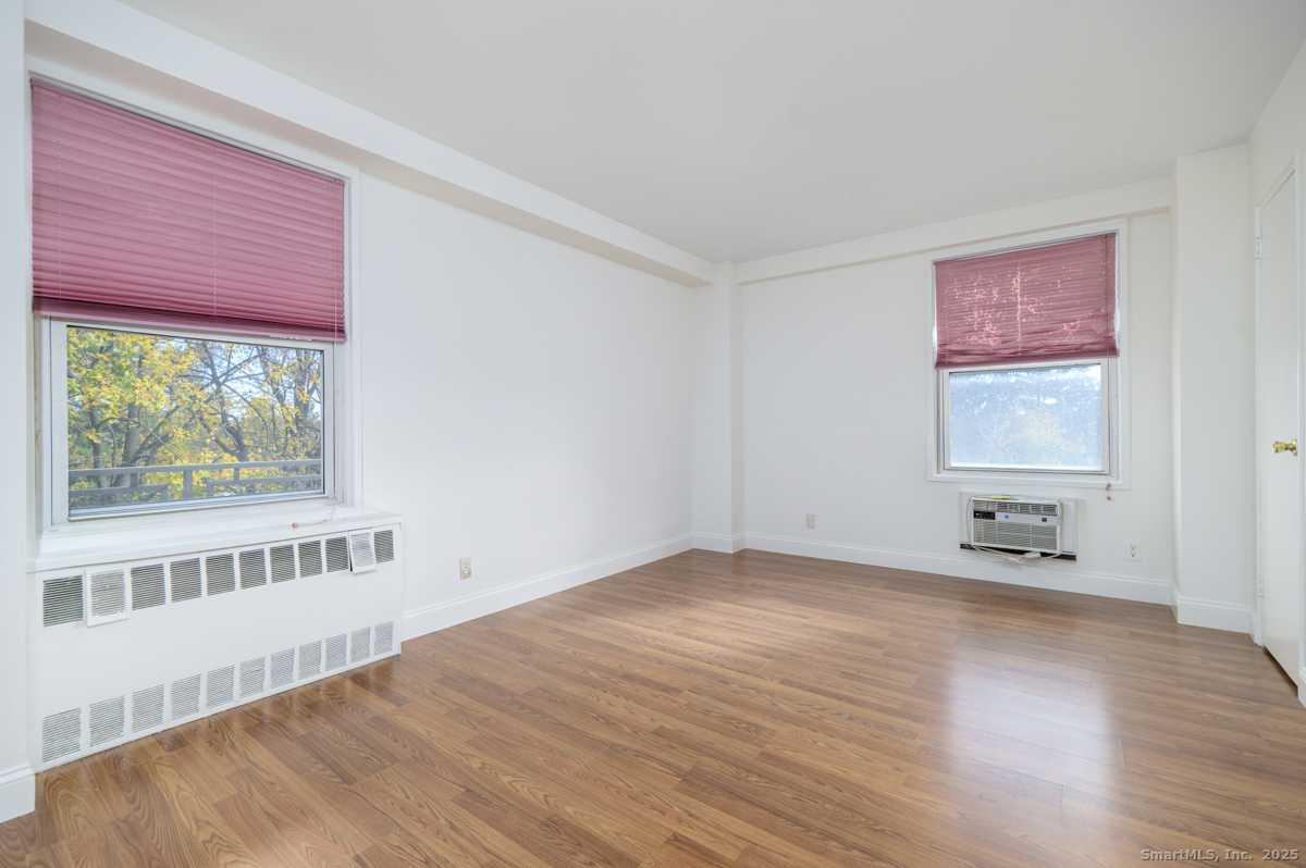 91 Strawberry Hill Avenue, Unit 331 Stamford, CT 06902 - Photo 11 of 19 a view of an empty room with wooden floor and a window