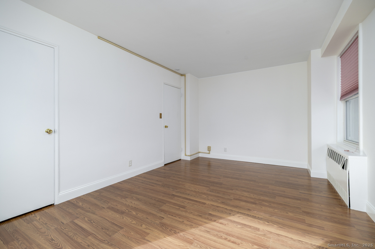91 Strawberry Hill Avenue, Unit 331 Stamford, CT 06902 - Photo 13 of 19 a view of empty room with wooden floor