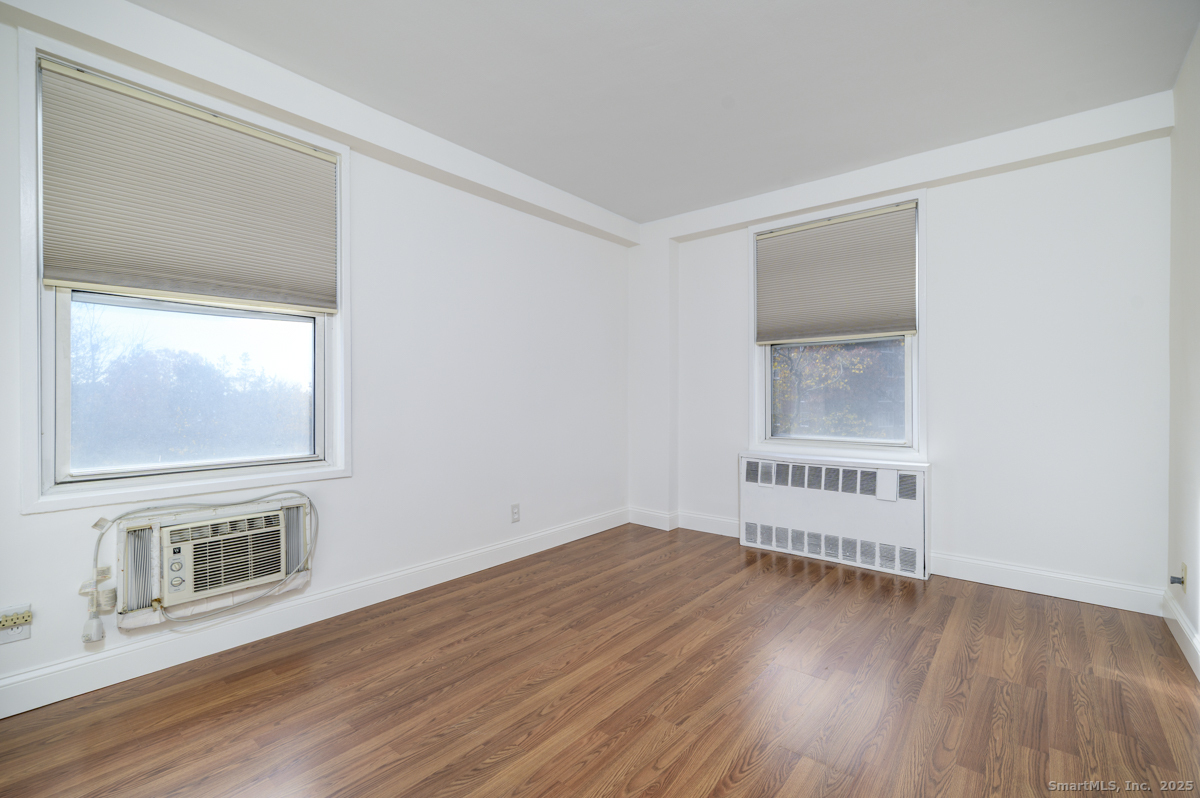 91 Strawberry Hill Avenue, Unit 331 Stamford, CT 06902 - Photo 14 of 19 a view of an empty room with wooden floor and a window