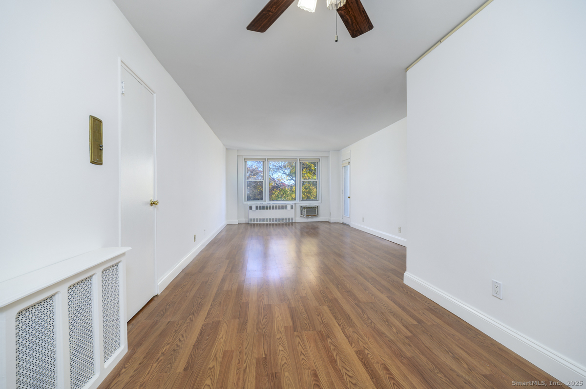 91 Strawberry Hill Avenue, Unit 331 Stamford, CT 06902 - Photo 3 of 19 wooden floor in an empty room with a window