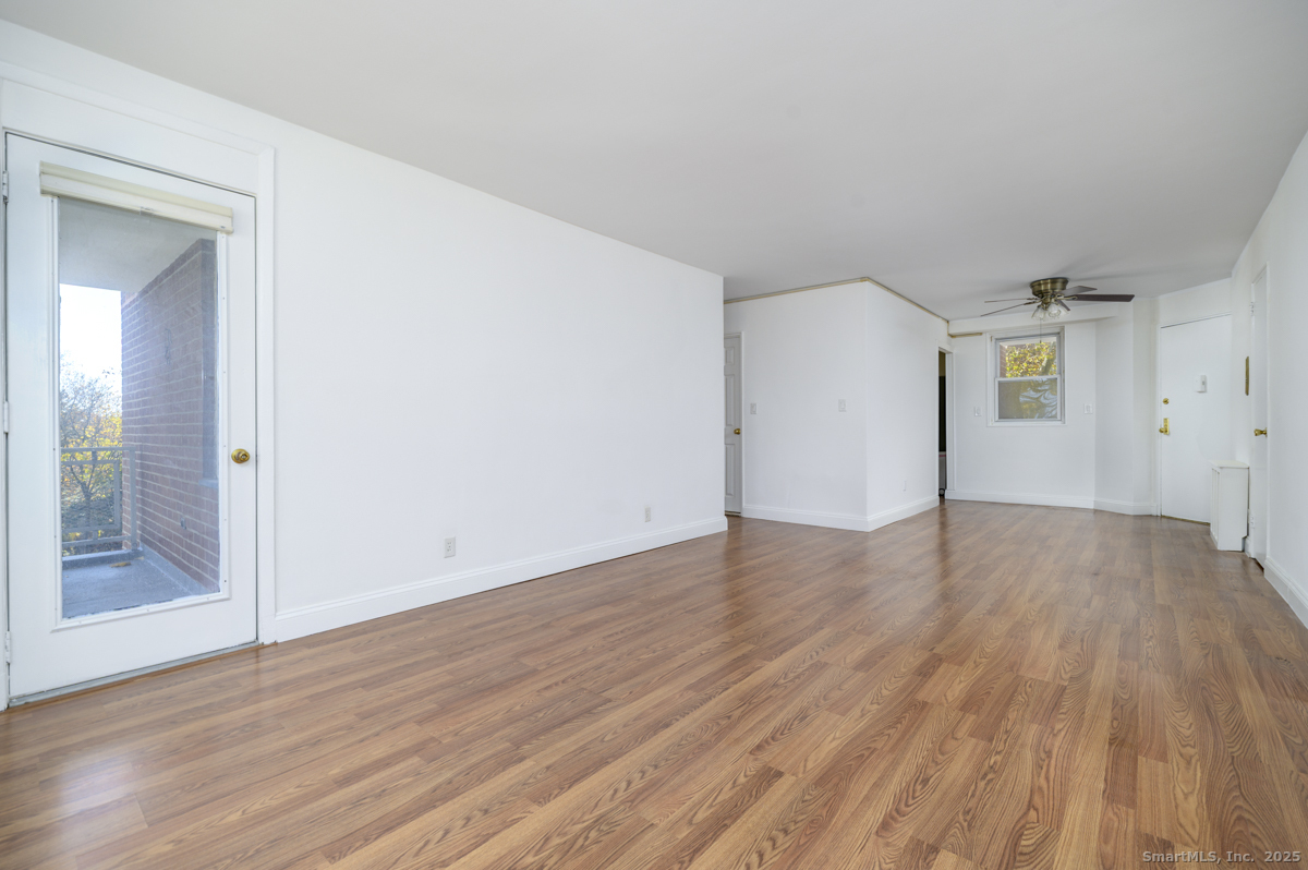 91 Strawberry Hill Avenue, Unit 331 Stamford, CT 06902 - Photo 4 of 19 an empty room with wooden floor and door